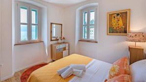 Una camera d'albergo con un letto, una cassettiera, uno specchio e un quadro.
