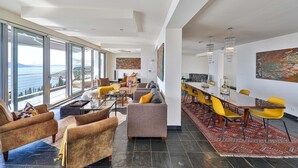 A spacious living area with a large window overlooking a scenic view, a dining area with yellow chairs, and a modern interior design. - Amazing home in Orasac (Orasac)