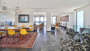 A spacious living area with a dining table, yellow chairs, a patterned sofa, and a large window offering a view. - Amazing home in Orasac (Orasac)