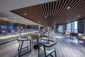A modern restaurant interior with a wooden ceiling, marble flooring, and a long counter with food displays.