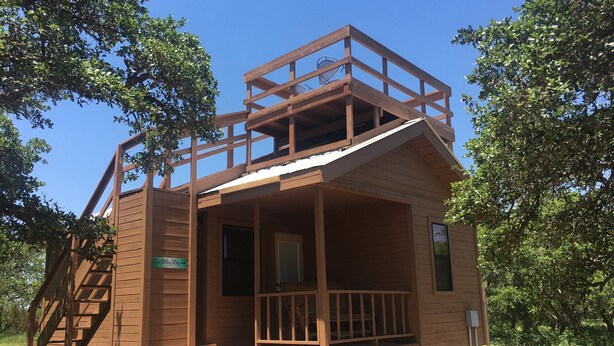 Une cabane en bois dotée d’un balcon, d’un escalier et d’une enseigne indiquant « The Wilky Way ».
