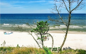 Ein Strand mit freiem Blick auf das Meer, ein paar Personen und ein kleines Boot.
