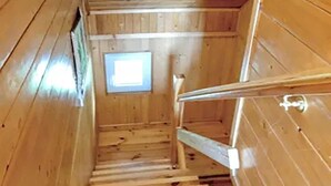 Un escalier en bois menant à une petite fenêtre.