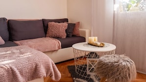 Un salon chaleureux avec un canapé, une table basse ronde et un tapis.