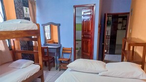 Un dormitorio con literas, un escritorio, una silla y un espejo.