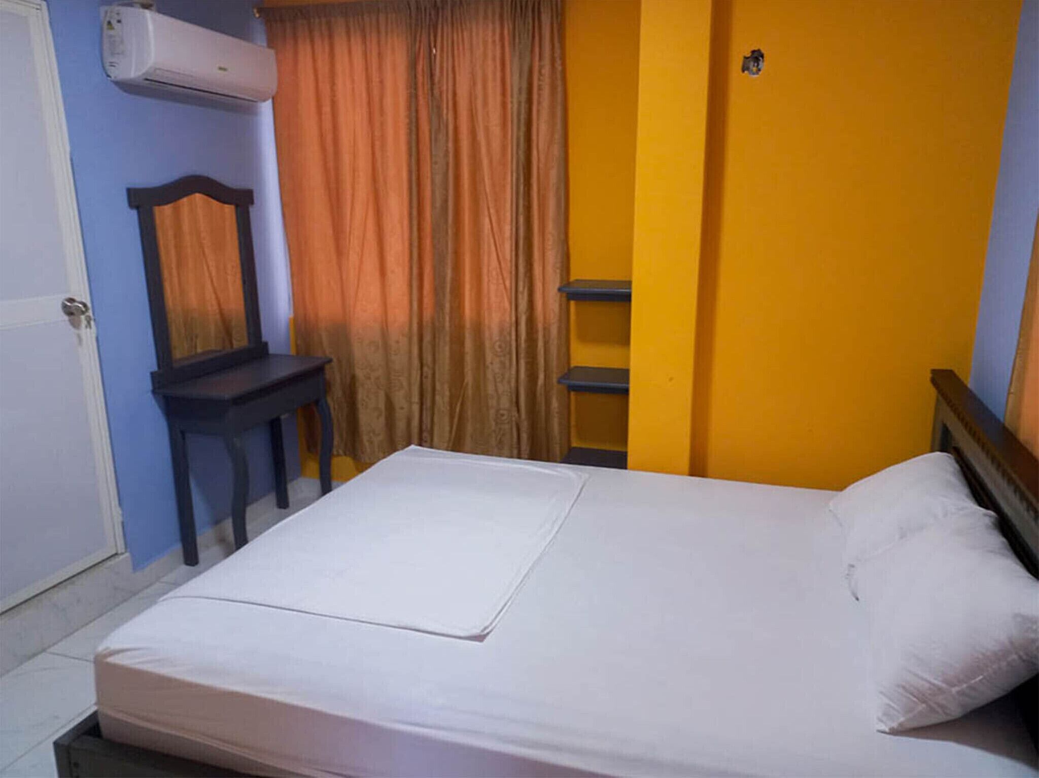 Una habitación con una cama, un escritorio y una silla.