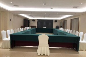 A conference room with a long table, white chairs, and a white chair in the foreground. - Anfu Jiangjing Hotel (Anfu)