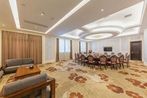 A conference room with a round table, chairs, and a television screen. - Anfu Jiangjing Hotel (Anfu)