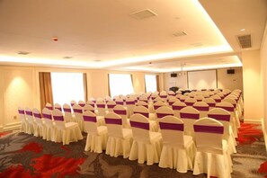 A conference room with rows of chairs, a carpeted floor, and a large window. - Anfu Jiangjing Hotel (Anfu)