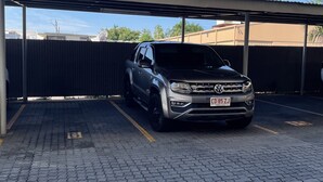 A Volkswagen SUV parked in a covered parking area with a paved ground. - Perfect little home away from home in the tropics. (Parap)