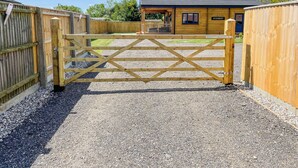 A wooden gate leading to a building with a sign reading "AYLESBURY." - Indulge and delight at this wonderful lodge, with your own private hot tub. (Halstead)
