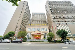 A multi-story building with a prominent entrance, several windows, and flags.