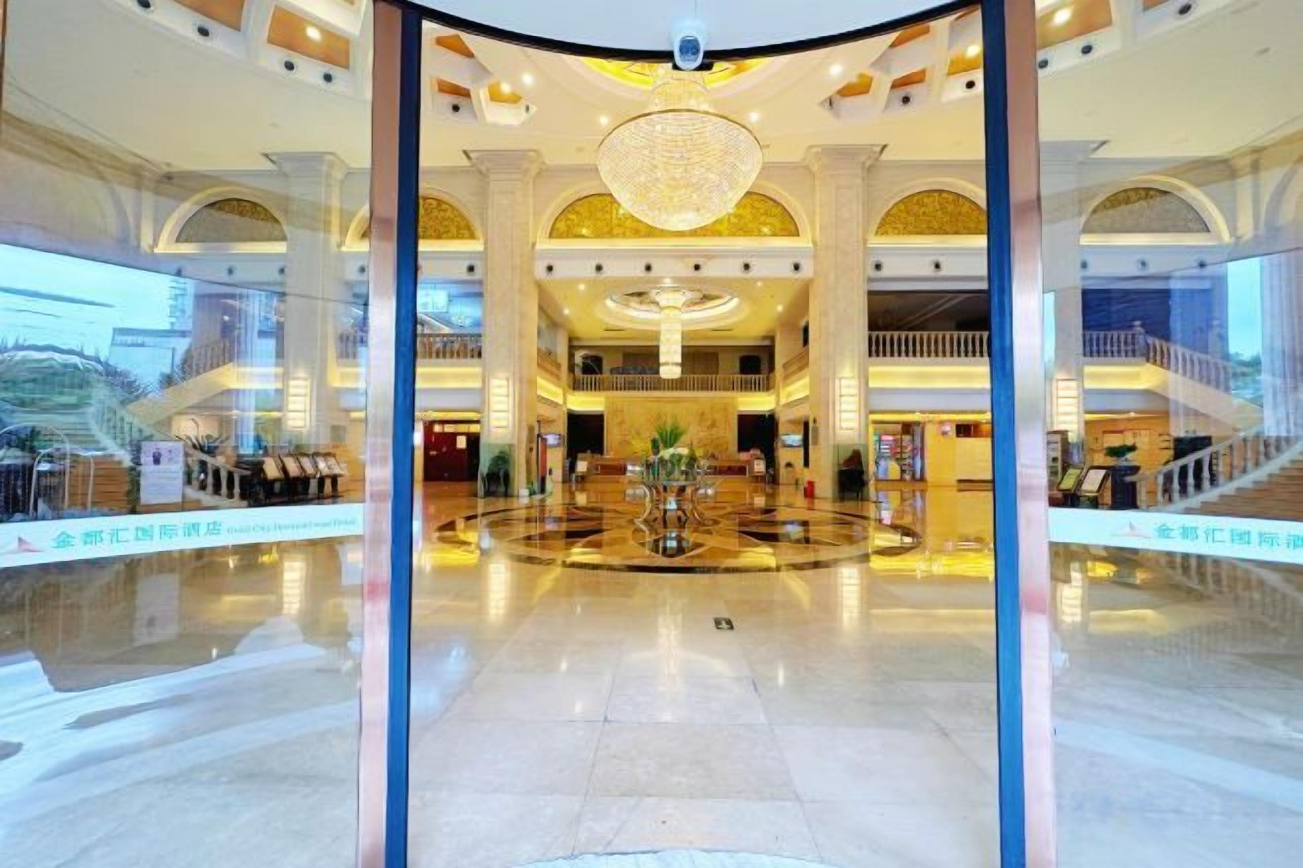 A spacious lobby with a central fountain, high ceilings, and a grand chandelier.