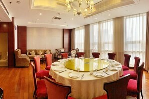 A conference room with a round table, red chairs, and a chandelier. - Jinduhui International Hotel (Guiyang Ouyanghai Plaza) (Guiyang)