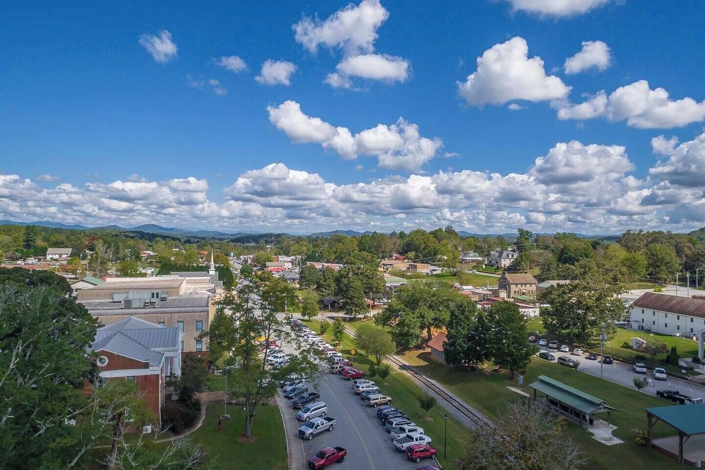A town with a parking lot, buildings, and a church.