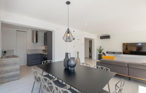 Enjoy a spacious living area with a dining table, comfortable seating, and a large flat-screen TV.