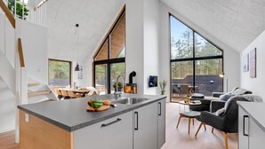A modern kitchen with a central island, large windows, and a dining area with a view of the outdoors. - 3 bedroom nice home in Rømø (Rømø)