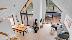 A spacious living area with a large wooden table, a sofa, and a fireplace. - 3 bedroom nice home in Rømø (Rømø)