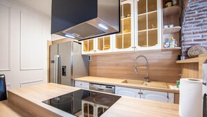 A modern kitchen with a built-in stove, stainless steel appliances, and wooden cabinetry.