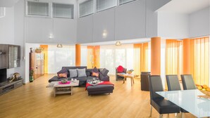 A spacious living area with a sofa set, a dining table with chairs, and a television. - Lovely home in Valtura (Valtura)