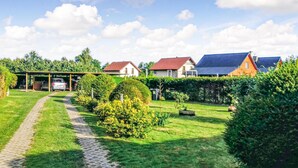 A residential area with houses, a covered car parking area, and a well-maintained garden with a pathway. - Beautiful apartment in Kopalino (Kopalino)