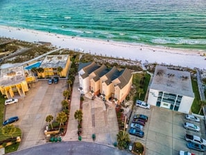 An aerial view of a coastal hotel with a parking lot, beach access, and a pool area. - 5 STAR BEACH FRONT RENOVATED TOWNHOME with BEACH SERVICE on Okaloosa Island (Fort Walton Beach)