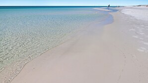 A beach with clear shallow waters and a sandy shore. - 5 STAR BEACH FRONT RENOVATED TOWNHOME with BEACH SERVICE on Okaloosa Island (Fort Walton Beach)