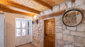 A hallway with stone walls, wooden beams, and a wooden door. - Lovely home in Glavina donja (Glavina donja)