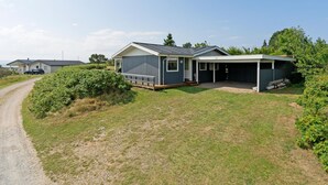 A single-story house with a covered porch and a fenced yard.