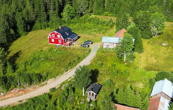 Escape to a serene rural retreat surrounded by dense forest and a picturesque barn.