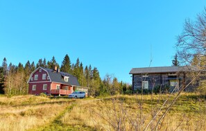 Two charming buildings set amidst a serene rural landscape, surrounded by evergreen trees.