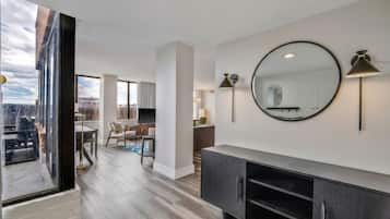 A modern interior with a large mirror, a dark console, and a dining area with a view.