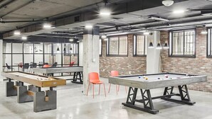 A spacious indoor area with a pool table, foosball table, and seating area. - Global Luxury Suites at Georgetown (Washington)