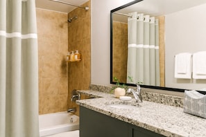 A bathroom with a shower, a sink with a mirror, and a towel rack. - Global Luxury Suites at Georgetown (Washington)
