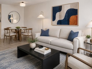 A modern living room with a sofa, coffee table, and dining area. - Global Luxury Suites at Georgetown (Washington)
