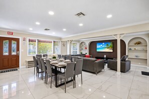 A modern interior with a dining area, seating, and a television.