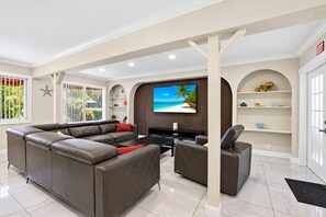 A modern living room with a sectional sofa, a flat-screen TV, and a coffee table.
