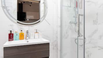 Een douche, handdoeken, zeep, toiletpapier