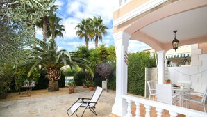 A patio with stone flooring, a white railing, and a seating area with chairs and a table. - Nice apartment in villa for 4 people with A/C, WIFI, pool, TV and terrace (Calpe)