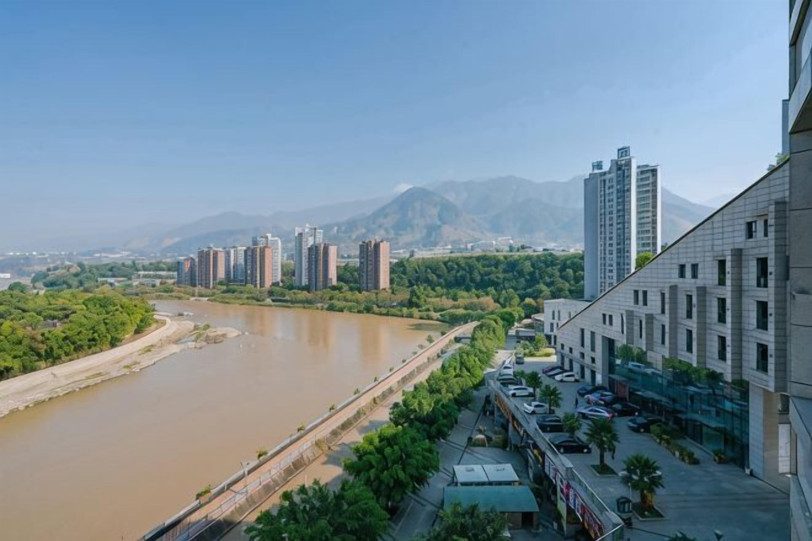 A river with buildings and mountains in the background.