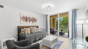 A modern bedroom with a bed, bedside tables, a glass coffee table, and a balcony with a view. - Yacht Club Miami Suite 2 Bedroom and 2 Bathroom With Baby Crib & Free Parking (Aventura)
