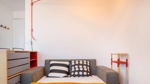 Ein Schlafzimmer mit einem Bett, einem Kleiderschrank, einem Schreibtisch und einem Stuhl.