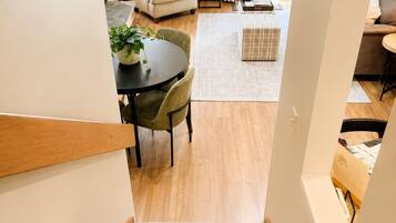 Una escalera conduce a un comedor con una mesa, sillas y una planta en maceta.