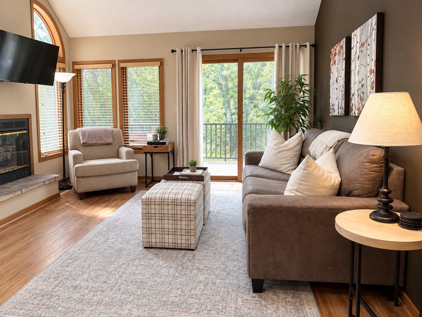 A living room with a fireplace, a sofa, a coffee table, and a TV mounted on the wall.