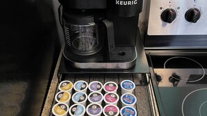 A Keurig coffee maker on a kitchen counter with a coffee pod holder below it. - Golf Villa - Pool Access + Private Deck (Galena)