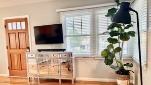 A living room with a TV, a wooden cabinet, a large plant, and a floor lamp. - RustlingLeaves.Kg&Qn.2ndFlrGarageLaundry (Los Angeles)