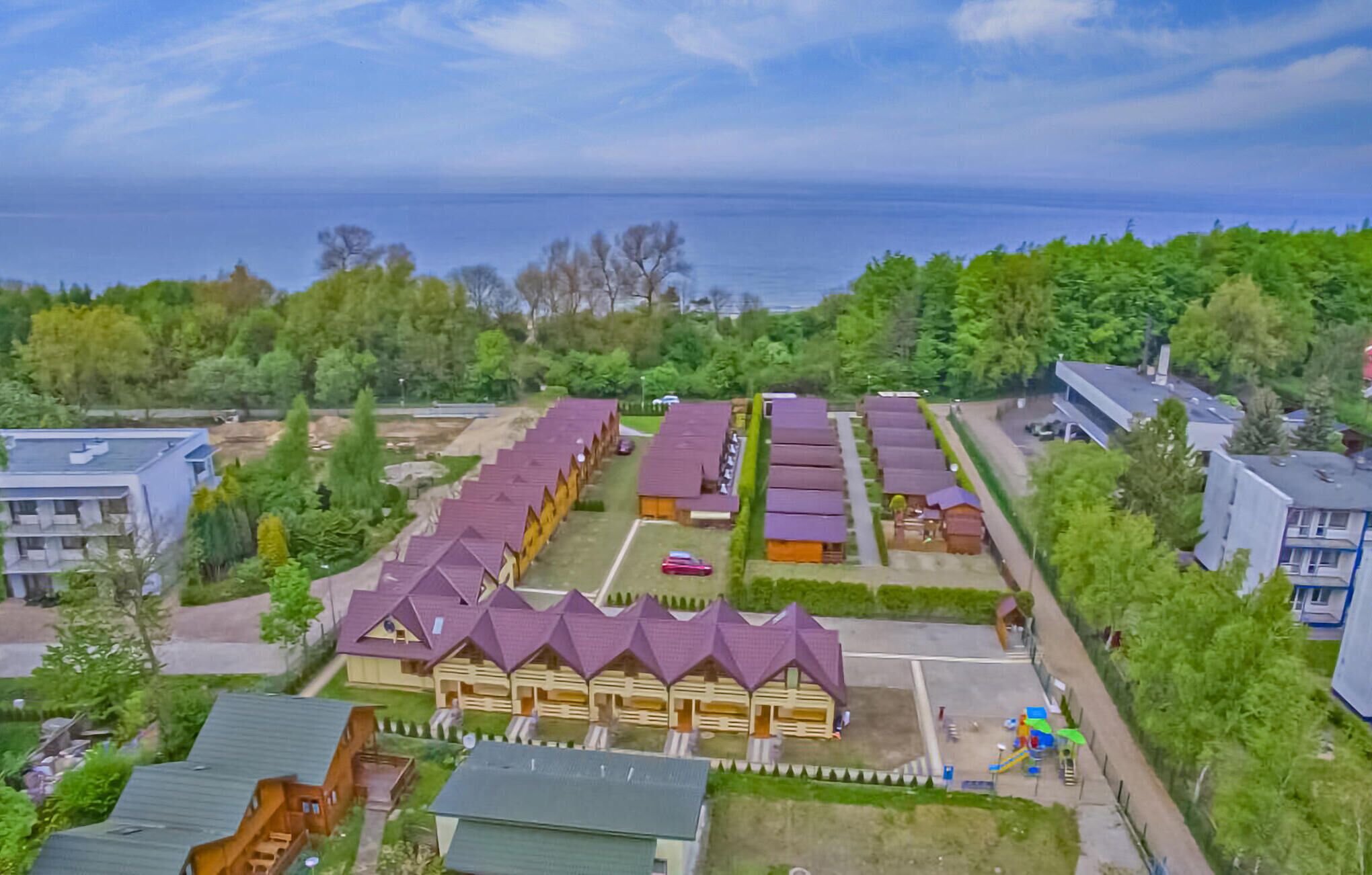 Un edificio grande con varias habitaciones, un parque infantil y vistas al mar.
