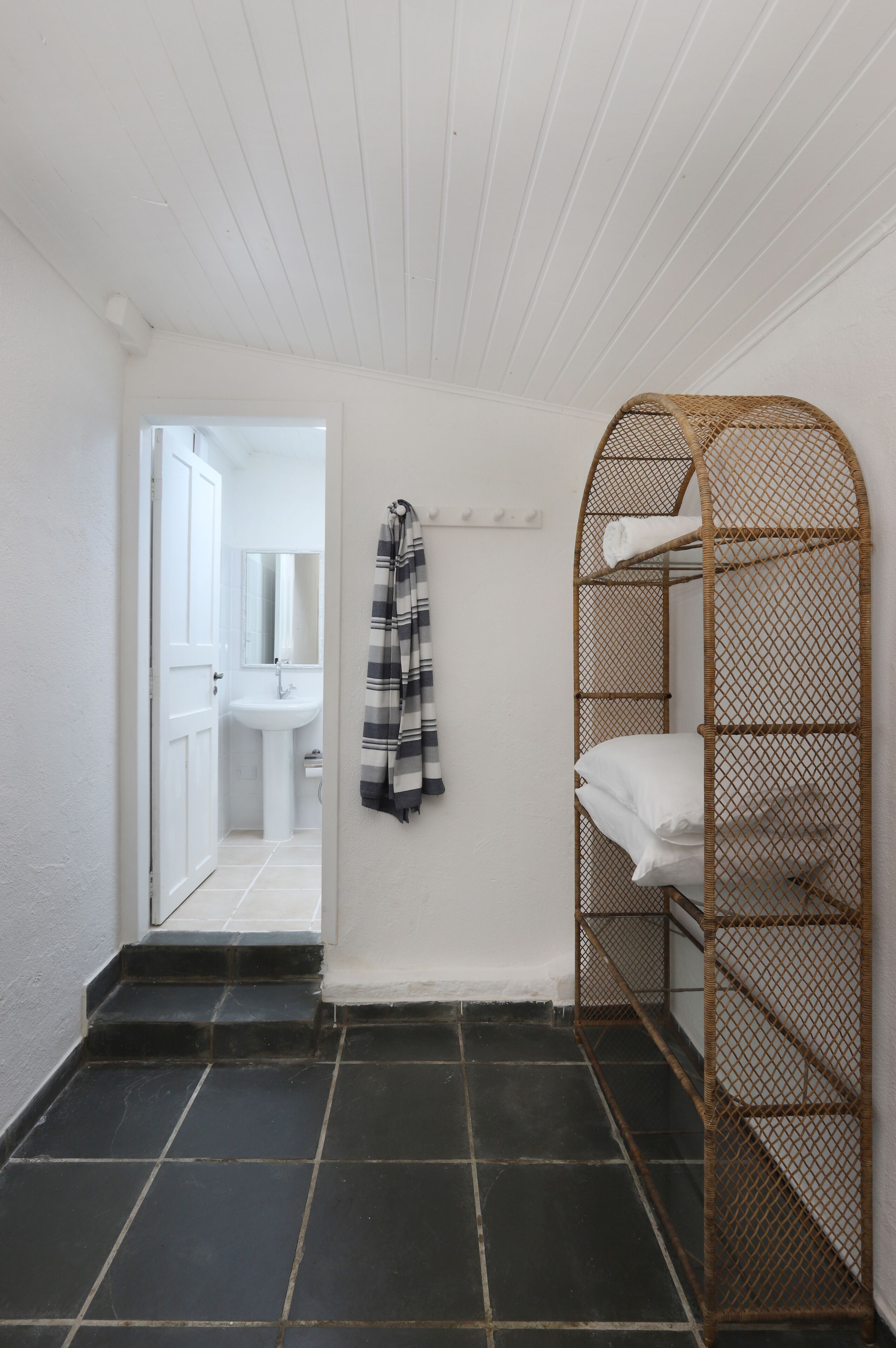 Een badkamer met een wit wastafel, een spiegel en een handdoekhouder.