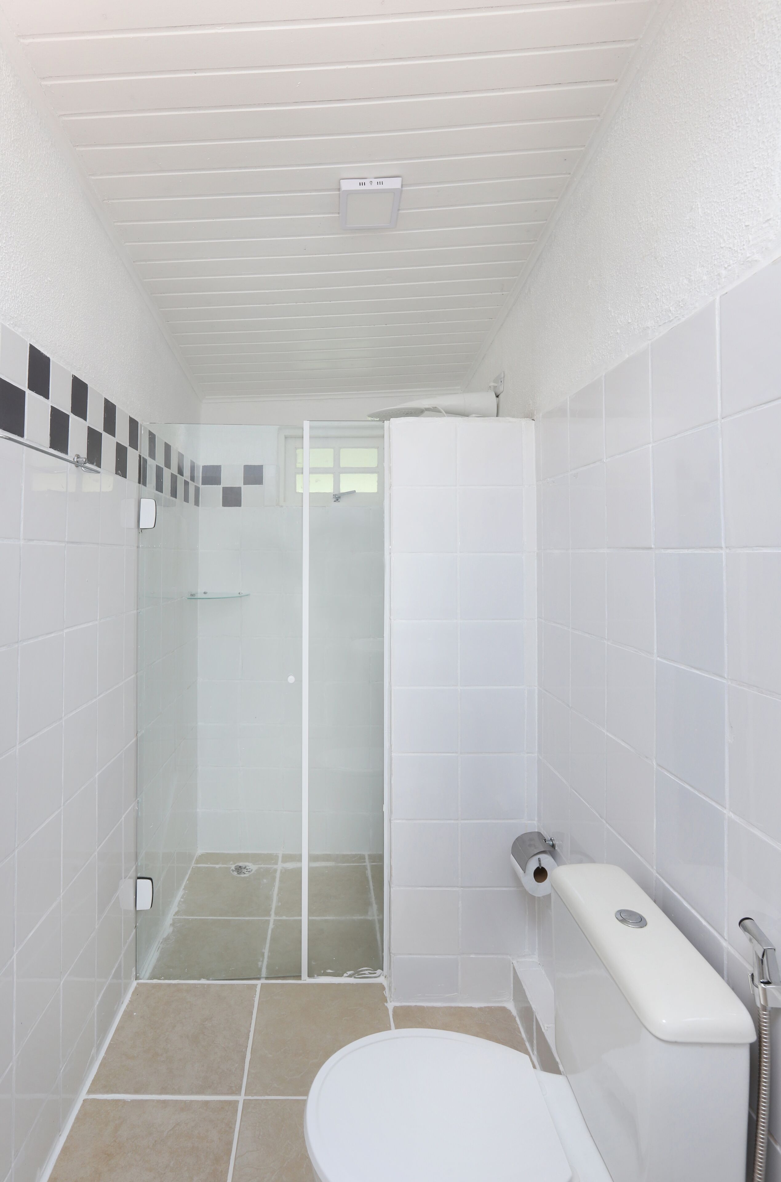 A bathroom with a toilet, a shower stall, and a sink.