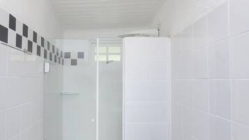 A bathroom with a toilet, a shower stall, and a sink.